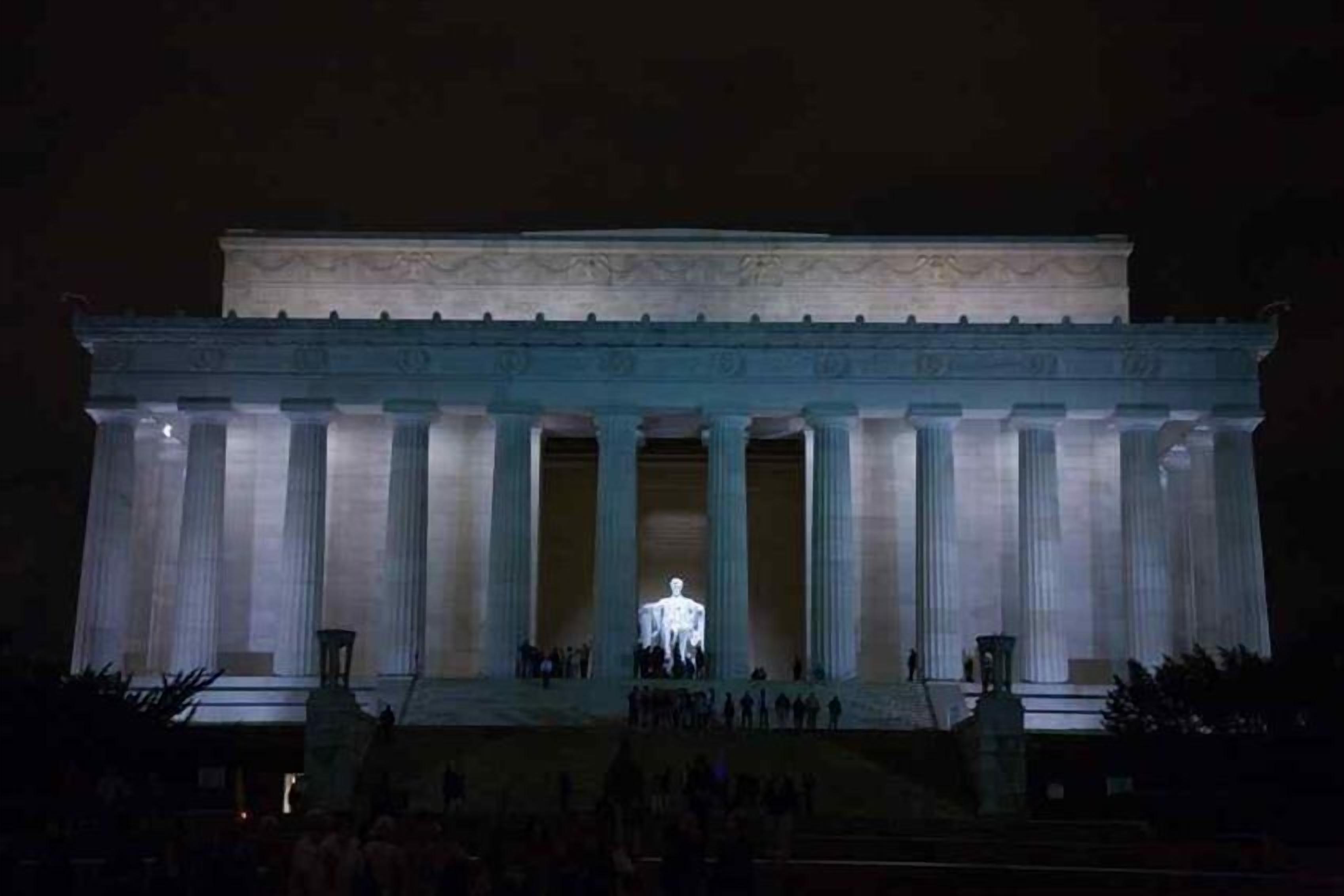 A large neoclassical building with a central statue, large columns, and a prominent entrance.