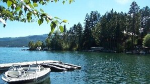 En båt låg förtöjd vid en brygga, och i bakgrunden såg man en kustlinje med skog.