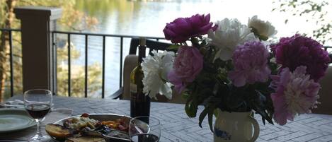 Una tavola imbandita con un pasto, bicchieri da vino e un vaso di fiori.