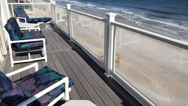 Una terraza con barandillas blancas que da a una playa.