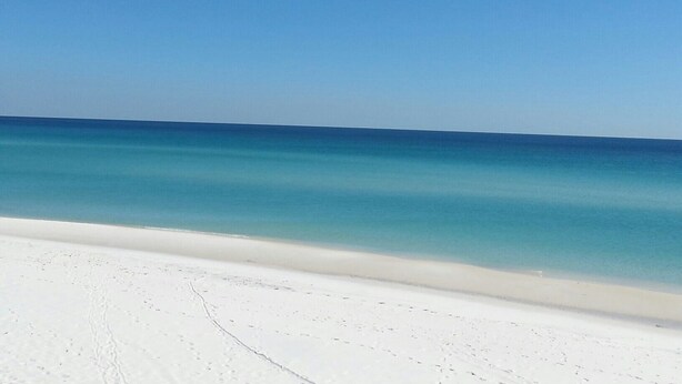 A beach with white sand and clear blue water. - Waterfront Home with Golf Cart, Kayaks, Bikes and Paddleboards! (Navarre Beach)
