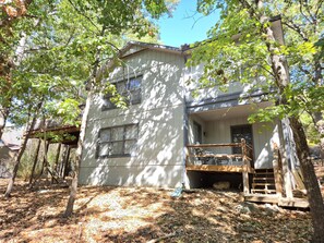 A two-story building with a balcony and a wooden deck.