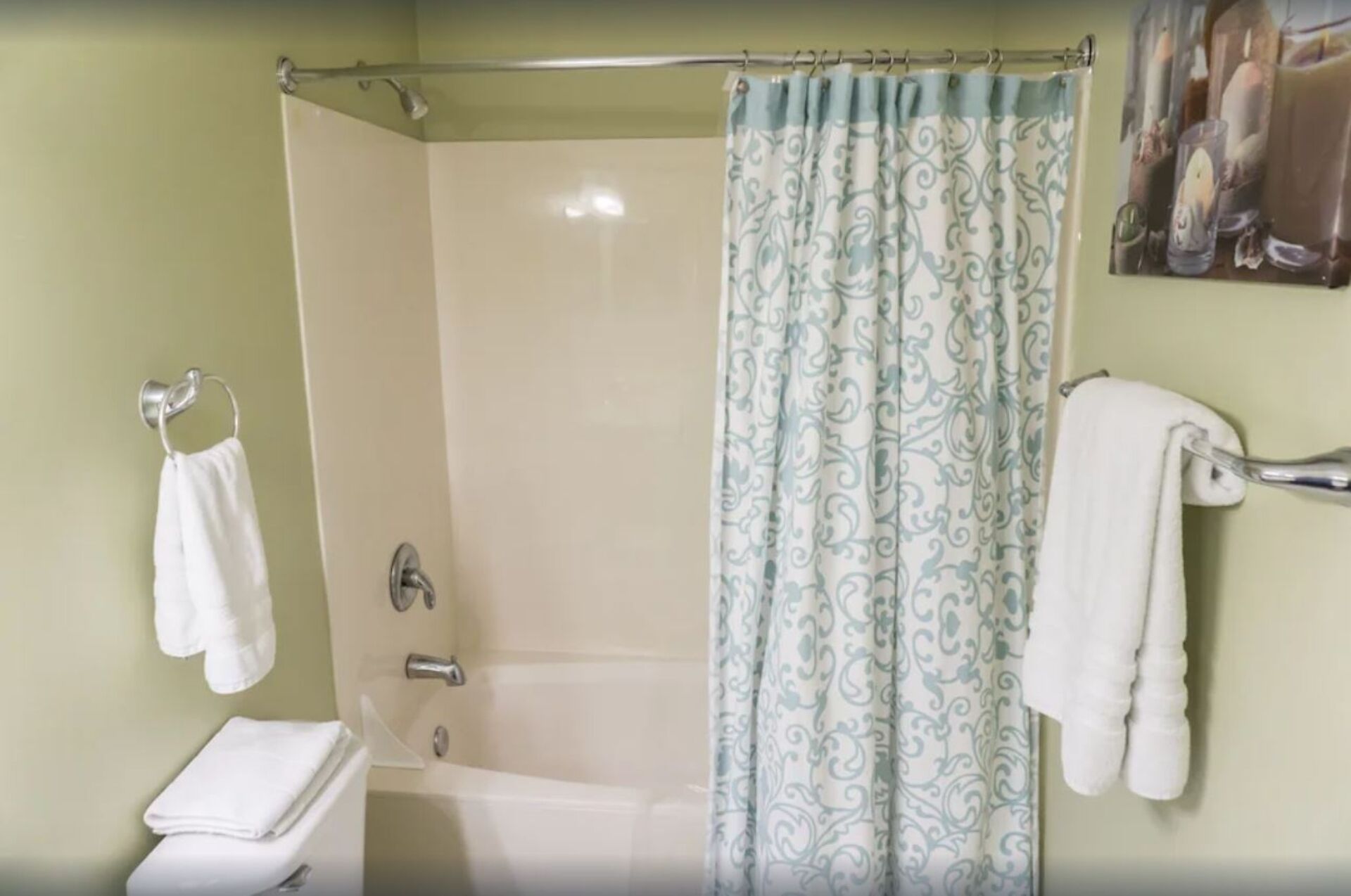 Une salle de bain avec une douche, une baignoire et des toilettes. Des serviettes sont accrochées à des crochets.