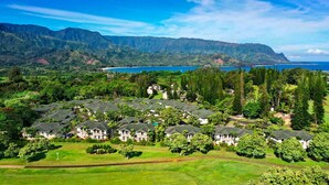 A residential area with houses surrounded by lush greenery and a view of a mountain range and a body of water. - Walk to Beach & Sunset-Luxury - Golf Course -2000sq ft - 3BR Pool&Jacuzzi (Princeville)