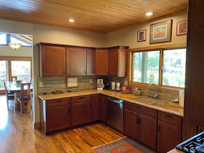Enjoy cooking in this well-lit kitchen with a dishwasher and large window offering a view of the surrounding landscape.