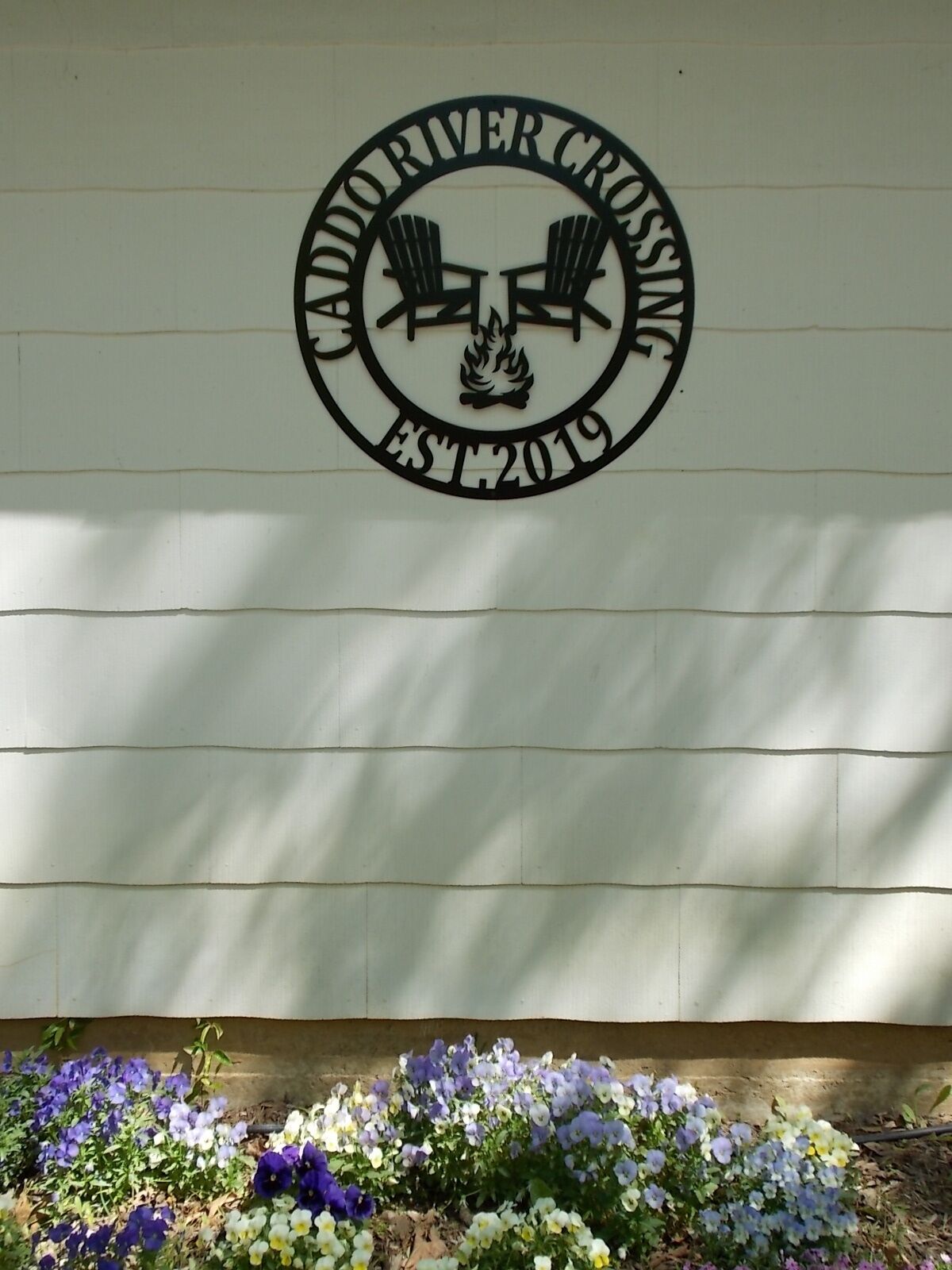 Un mur orné du logo de « Caddoriver Crossing » et de l’inscription « Fondé en 2019 ».