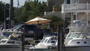 Una zona ribereña con barcos amarrados, un muelle y un edificio con balcón.
