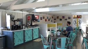Un café con barra, asientos y una máquina de Coca-Cola.