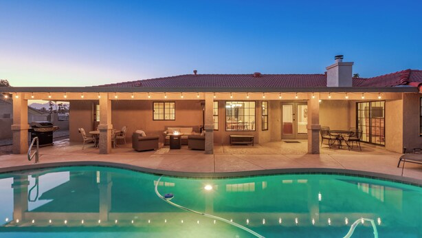 A house with a swimming pool, outdoor seating, and string lights. - Tail wags welcome! Close to Lake, Boat and RV Parking! (Lake Havasu City)