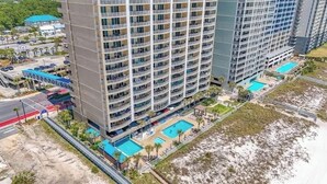 Ein Hochhaus-Hotel mit mehreren Balkonen, einem Pool und Blick auf den Strand.
