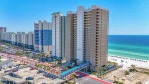 Ein Hochhotel mit mehreren Etagen, einer Fußgängerbrücke und Blick auf den Strand.