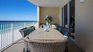 Ein Balkon mit Blick auf den Ozean, Korbmöbel und einem Blumentopf.
