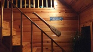 Un escalier en bois avec une pancarte indiquant : « LOCATION DE CANOËS – Laissez-vous porter par le courant ».