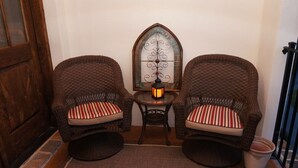Two wicker chairs with striped cushions, a small table with a candle, and a decorative wall piece. - Villa della Luna, an authentic Tuscan Villa in Montaluce, license #3857 (Dahlonega)