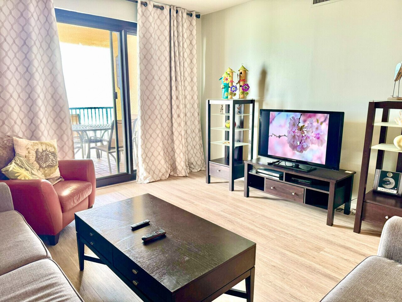 A living room with a sofa, a coffee table, a TV, and a bookshelf.