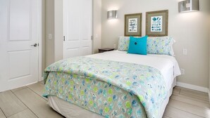 Ein Schlafzimmer mit einem Bett, zwei Wandleuchten und zwei gerahmten Bildern an der Wand.