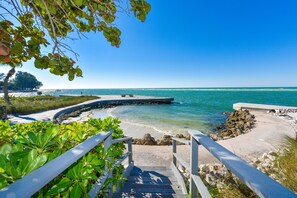 A coastal walkway leading to a beach with clear blue water, a wooden railing, and a view of the ocean. - Beautiful updated Siesta Key Condo,  pool,  beach, fishing pier in Sandy Cove 3 (Sarasota)