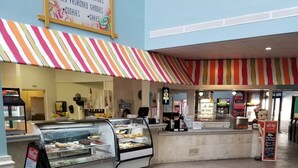 Un espace de restauration proposant une variété de desserts, notamment des glaces, des pâtisseries et des gâteaux.