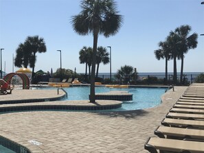 Relax by the pool surrounded by palm trees and enjoy a scenic ocean view.