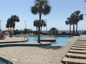 Relax by the pool surrounded by palm trees and enjoy a scenic ocean view.