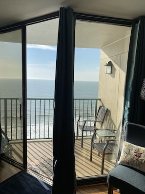 Enjoy the view from your balcony with a sliding glass door leading out to a seating area with a table and chairs.