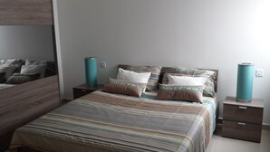Ein ordentlich eingerichtetes Schlafzimmer mit einem Bett, zwei Nachttischen und einem Beistelltisch.