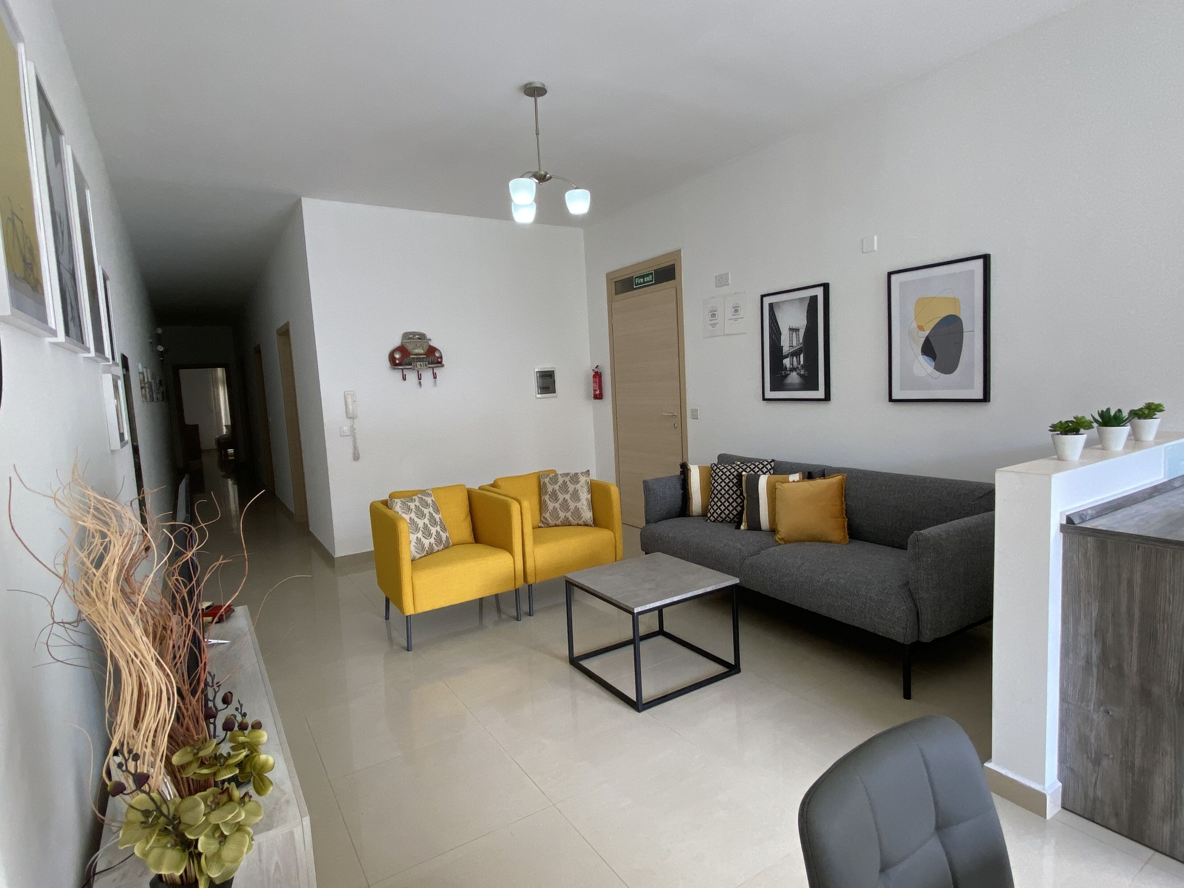 Una sala de estar moderna con un sofá, dos sillones, una mesa de centro y un comedor.