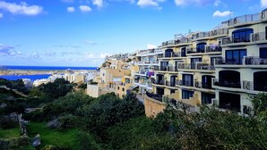 Ein Küstenwohngebiet mit mehrstöckigen Gebäuden, Balkonen und freiem Blick auf das Meer.