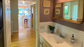A bathroom with a sink, mirror, and wall-mounted lights.