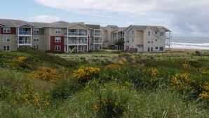 A coastal residential building with multiple balconies and a view of the ocean.