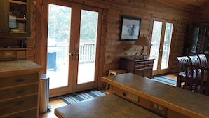 A wooden cabin kitchen with a large window, wooden cabinets, and a bench. -  Log Home in the NATIONAL FOREST.  ATV/SNOWMOBILE TRAIL CROSS OUR PROPERTY (Hayward)