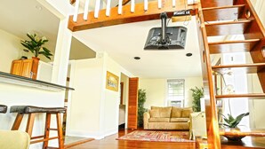 Ein geräumiger Wohnbereich mit einer Holztreppe, einem Sofa und einem Couchtisch.