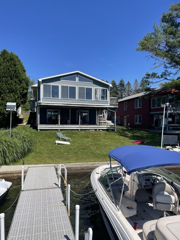 A house with a dock and a boat. - Beautiful Waterfront home with deep water dock on Onota Lake. Huge covered deck. (Pittsfield)