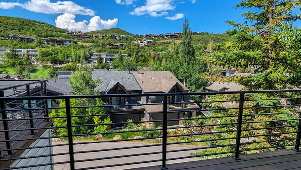 Un quartier résidentiel avec des maisons, une colline et un ciel dégagé.