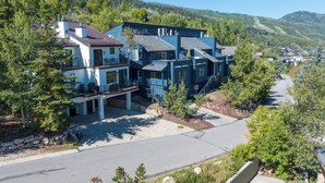 Un immeuble résidentiel à plusieurs étages doté d’une terrasse et d’un espace extérieur aménagé pour s’asseoir.