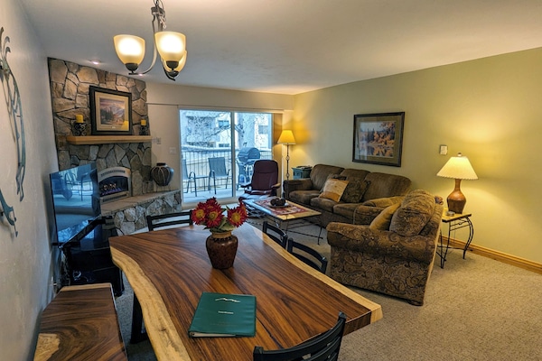 Living room with sofa bed, gas fireplace, dining table, and balcony w/ gas BBQ