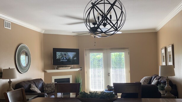 A dining area with a wooden table and chairs, a television on a stand, and a decorative ceiling light. - Great location!! Pool! Unit 5201- Mtn. View Condos, 3 Bed, 2 Bath (Pigeon Forge)