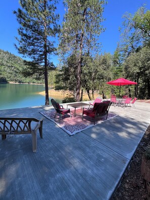 A deck with outdoor furniture, a table, and a red umbrella. - This home has it all and more!! Message me for video tour! (Lakehead)
