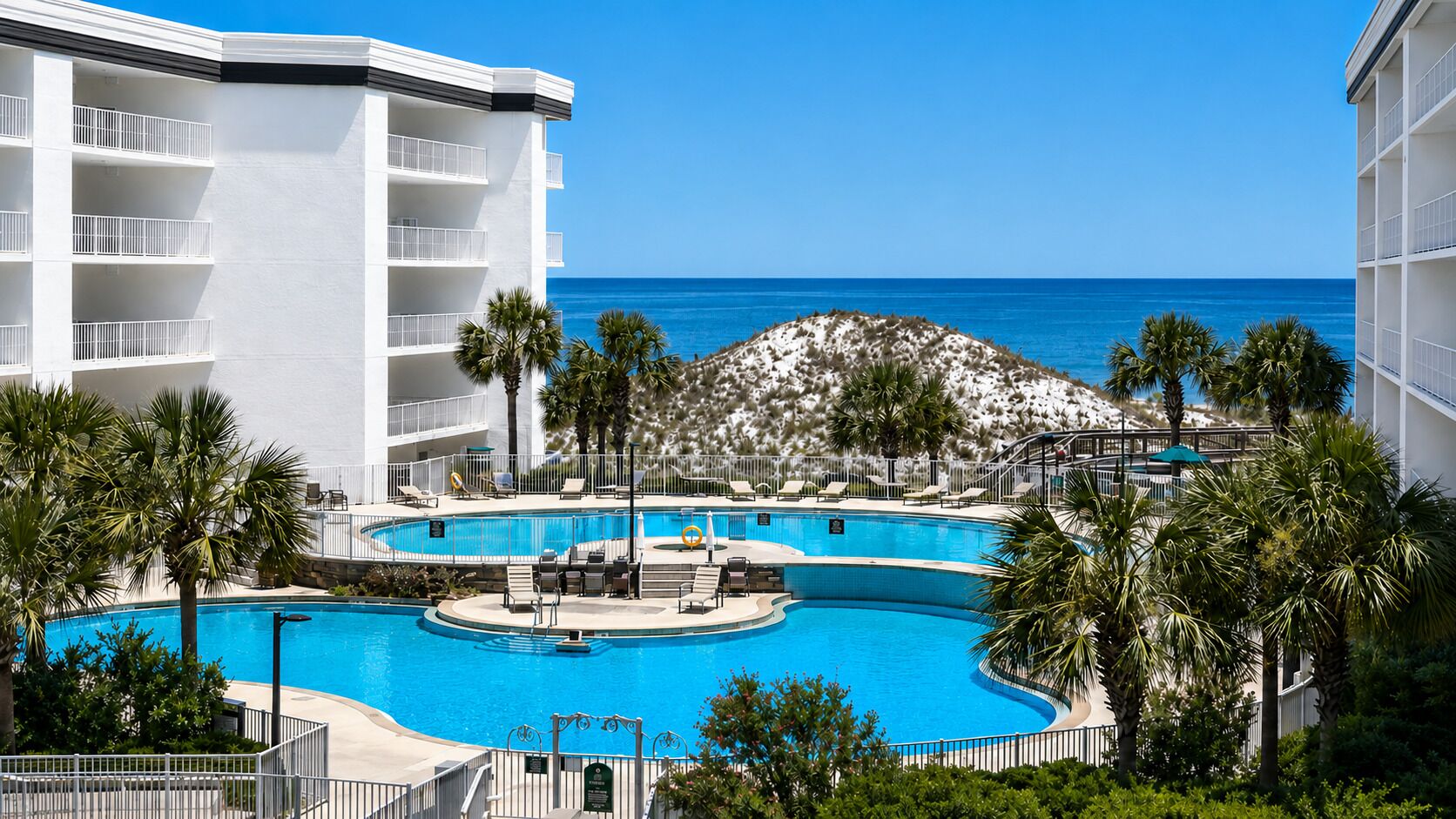 Ein Resort mit Pool, Palmen und Meerblick.