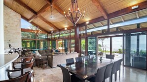 A spacious indoor area with a large dining table, comfortable seating, and a view of the outdoors. - Welcome to Casa Caiman | FULL STAFFED + 2 BOATS by Viridian Experience (peninsula papagayo)