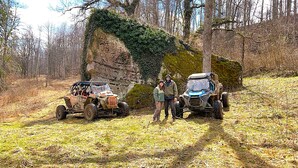 Two off-road vehicles parked on a dirt path in a forested area. - The Highlander Rustic Yurt (Genoa)