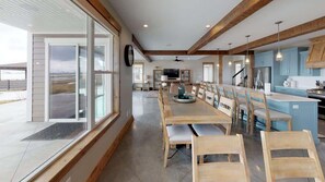 Una cocina amplia con vigas de madera, una isla grande y armarios azules.