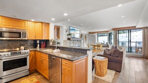 A modern kitchen with granite countertops, wooden cabinets, and stainless steel appliances.