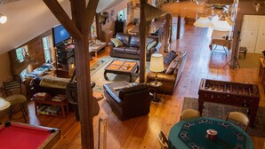 A spacious living area with a pool table, leather sofas, and a foosball table. - Country Getaway Lodge/Ranch near Saratoga Springs (valley Falls)