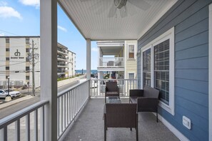 A balcony with wicker furniture, a view of the street, and a building with a sign 'decatur house'.