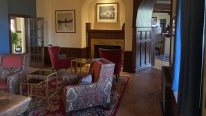 A cozy lounge area with patterned sofas, a fireplace, and a chandelier. - 7BR Pocono home on Skytop property+ access to many resort activities/golf/dining (Skytop)