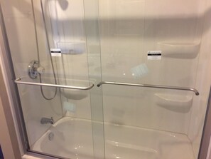 Een bad/douchecombinatie, een haardroger, handdoeken, zeep