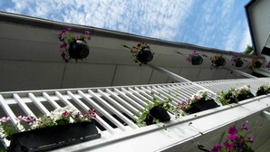 A balcony with white railings and flower planters. - Room 3 at Otter Creek Inn (Mt Desert)