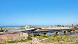 A coastal bridge with a road and a pedestrian path, overlooking a beach and ocean. - OCEAN VIEWS!!!! Penthouse located across the street to beach!! (Oceanside)