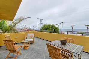 Enjoy breathtaking sea views from this balcony with comfortable seating and a small table.